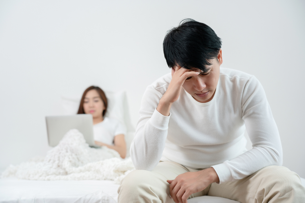 Asian men are sitting stressed about having sex. with their wife