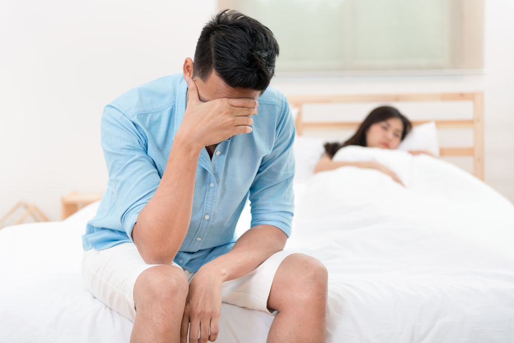 unhappy husband and wife in bed.