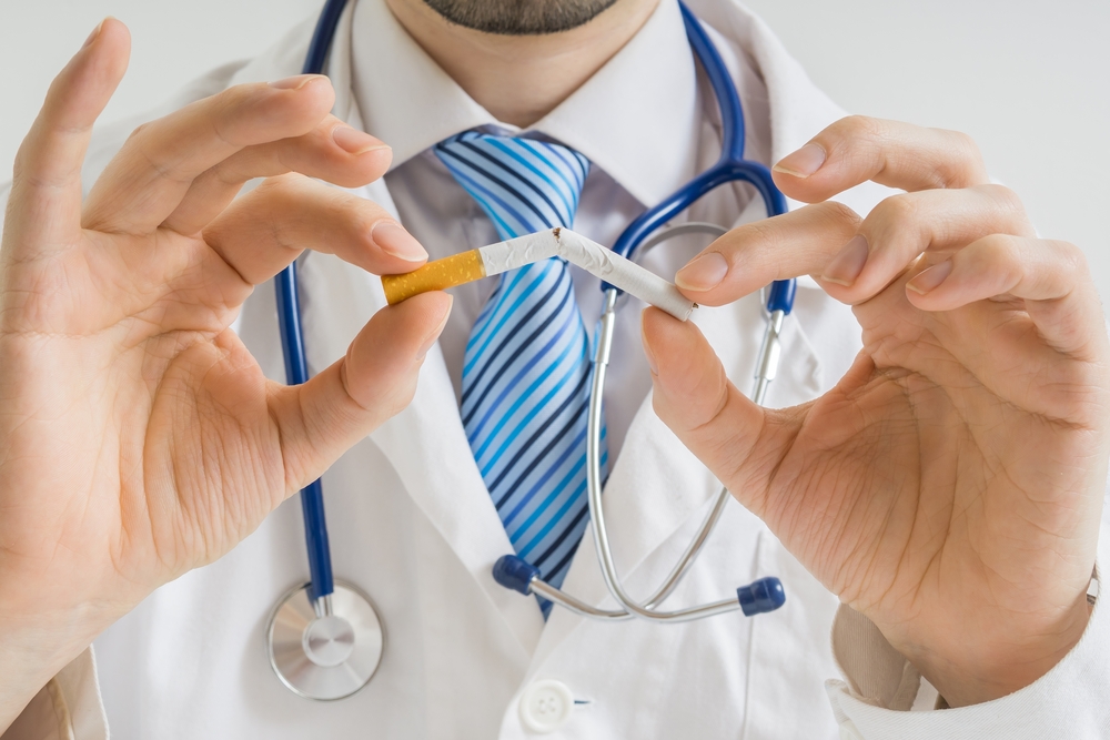 doctor breaking cigarette in half.