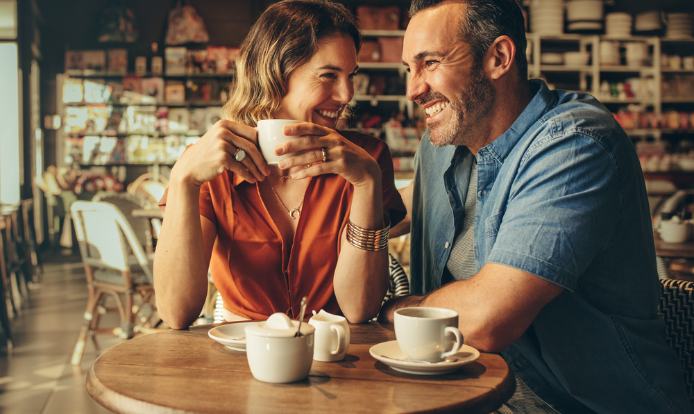 Happy man and woman sitting at coffee shop.