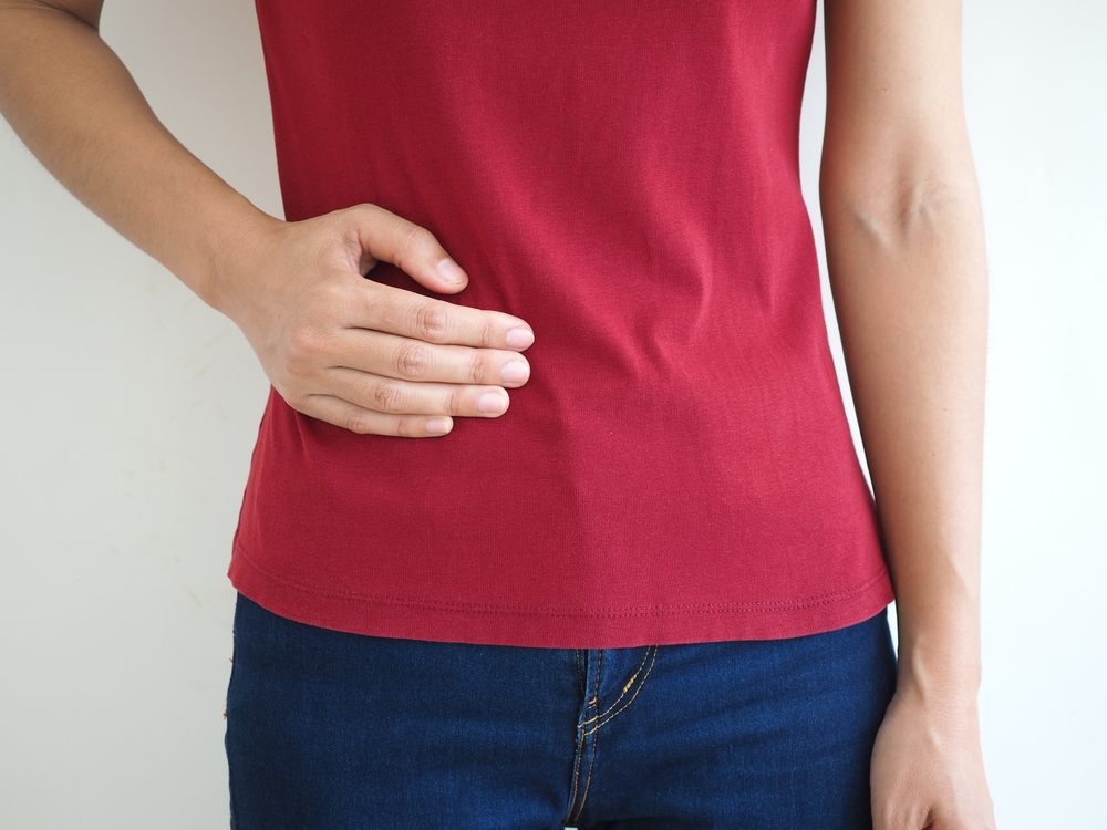 woman standing with hand on her stomach