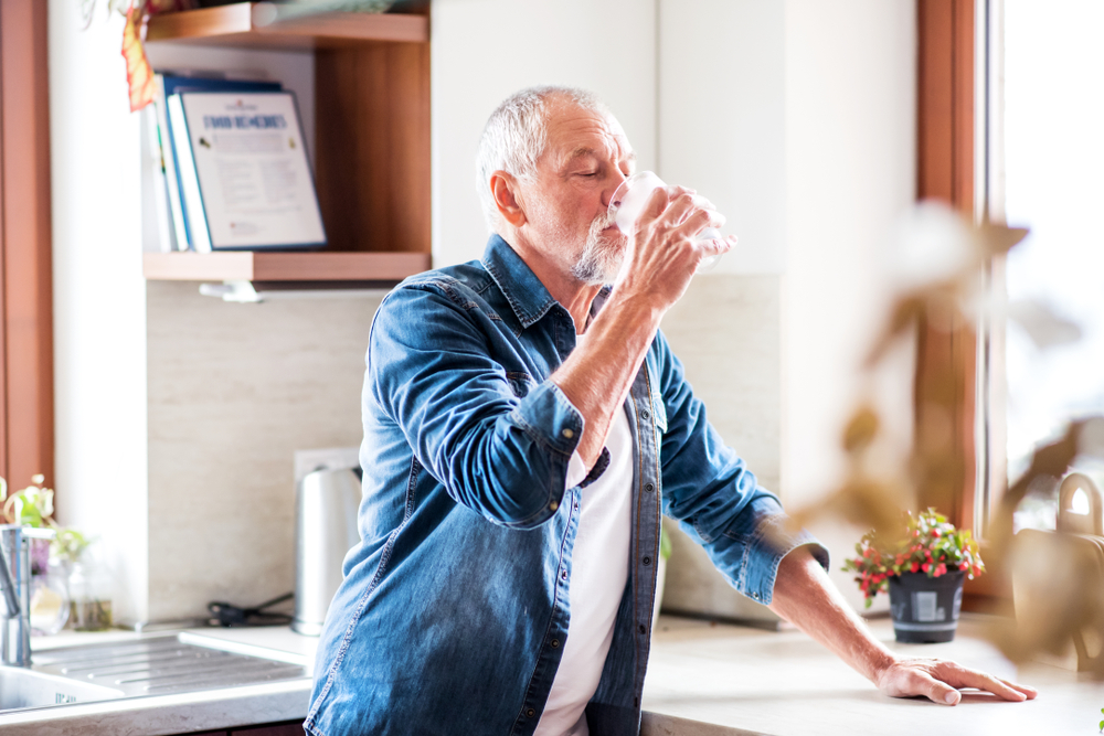 older man drinking water.