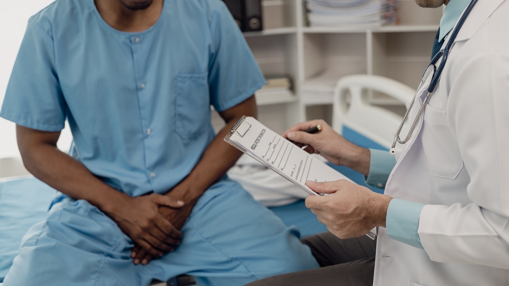 man sitting next to doctor.